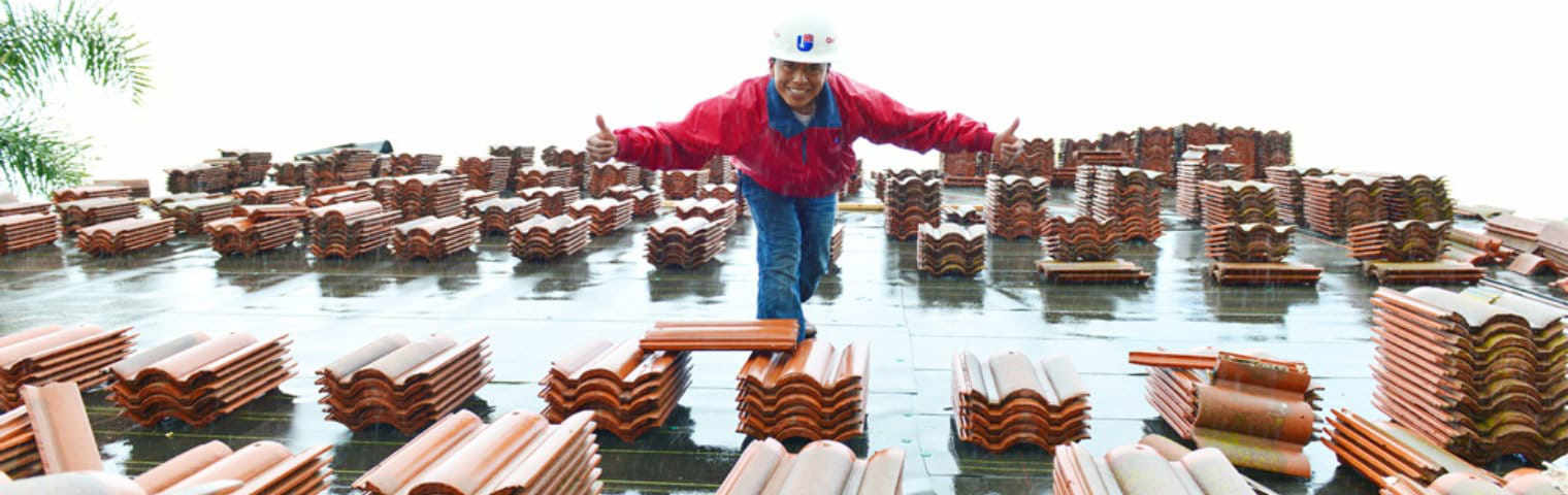 A man standing on top of a pile of wooden beams